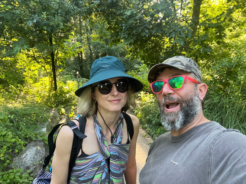 Two people standing in a lush green spot