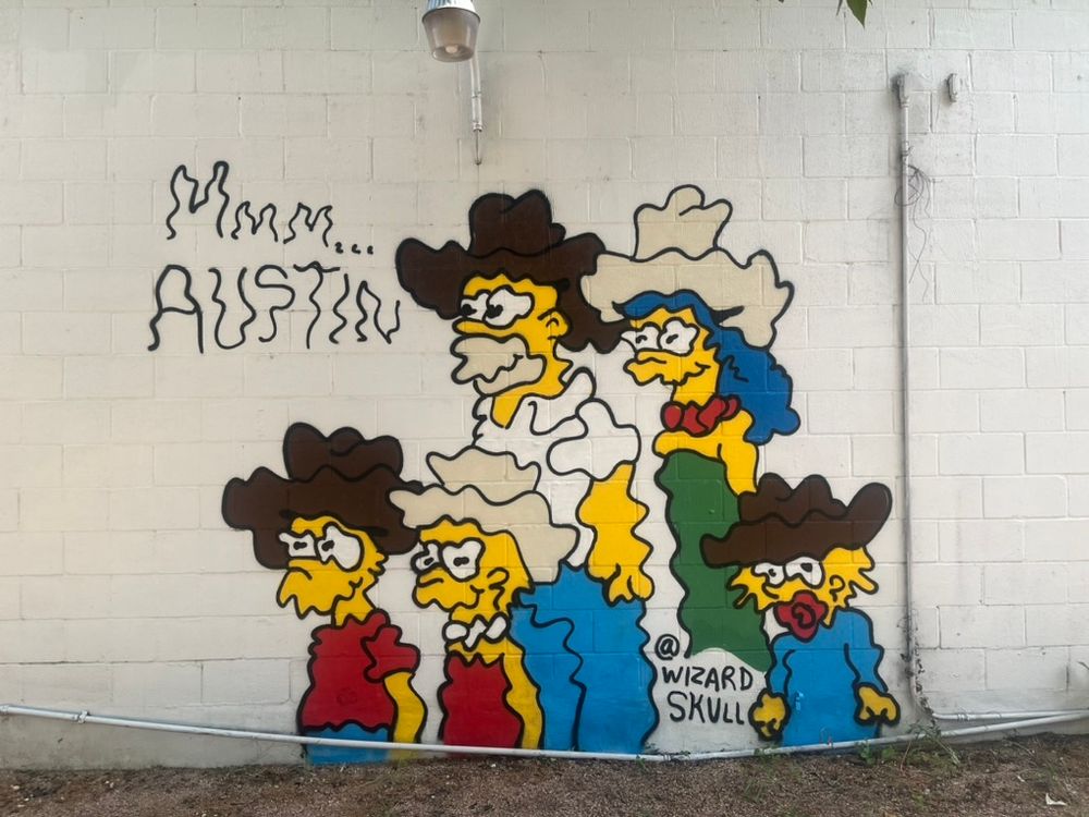 Street art of the Simpsons done in a wavy line style that makes them look extra trippy.