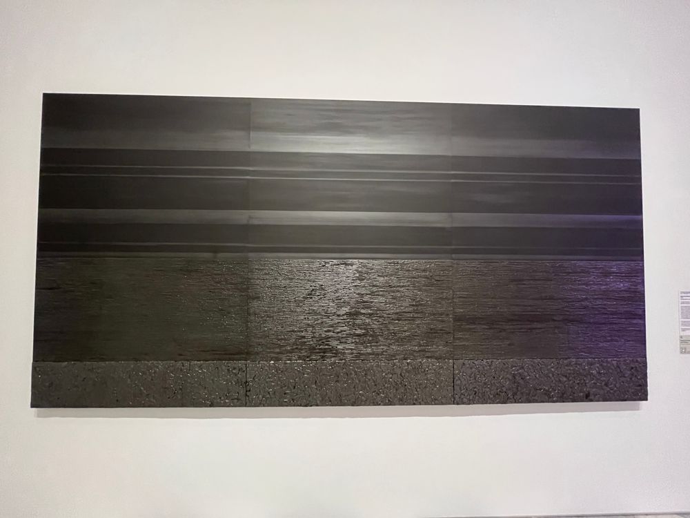 An all black image with textured sections that make it look like the ocean