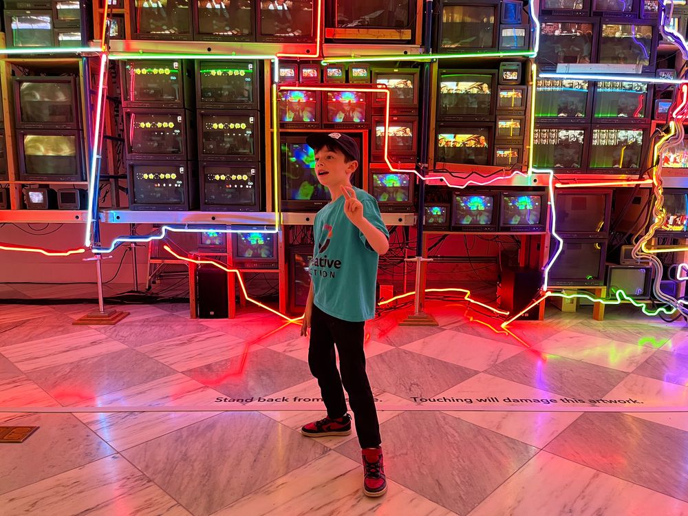 Desmond standing in front of a neon Texas