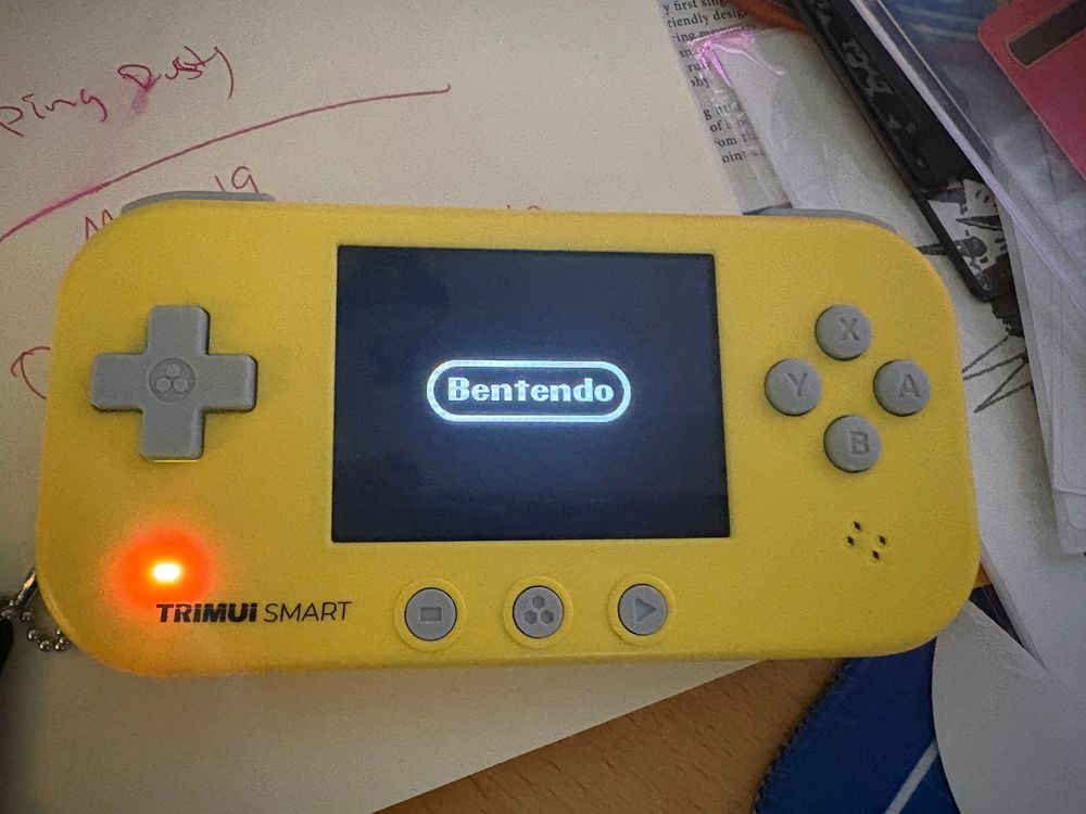 A yellow game system showing its boot up screen. It says "Bentendo" in the Nintendo font.